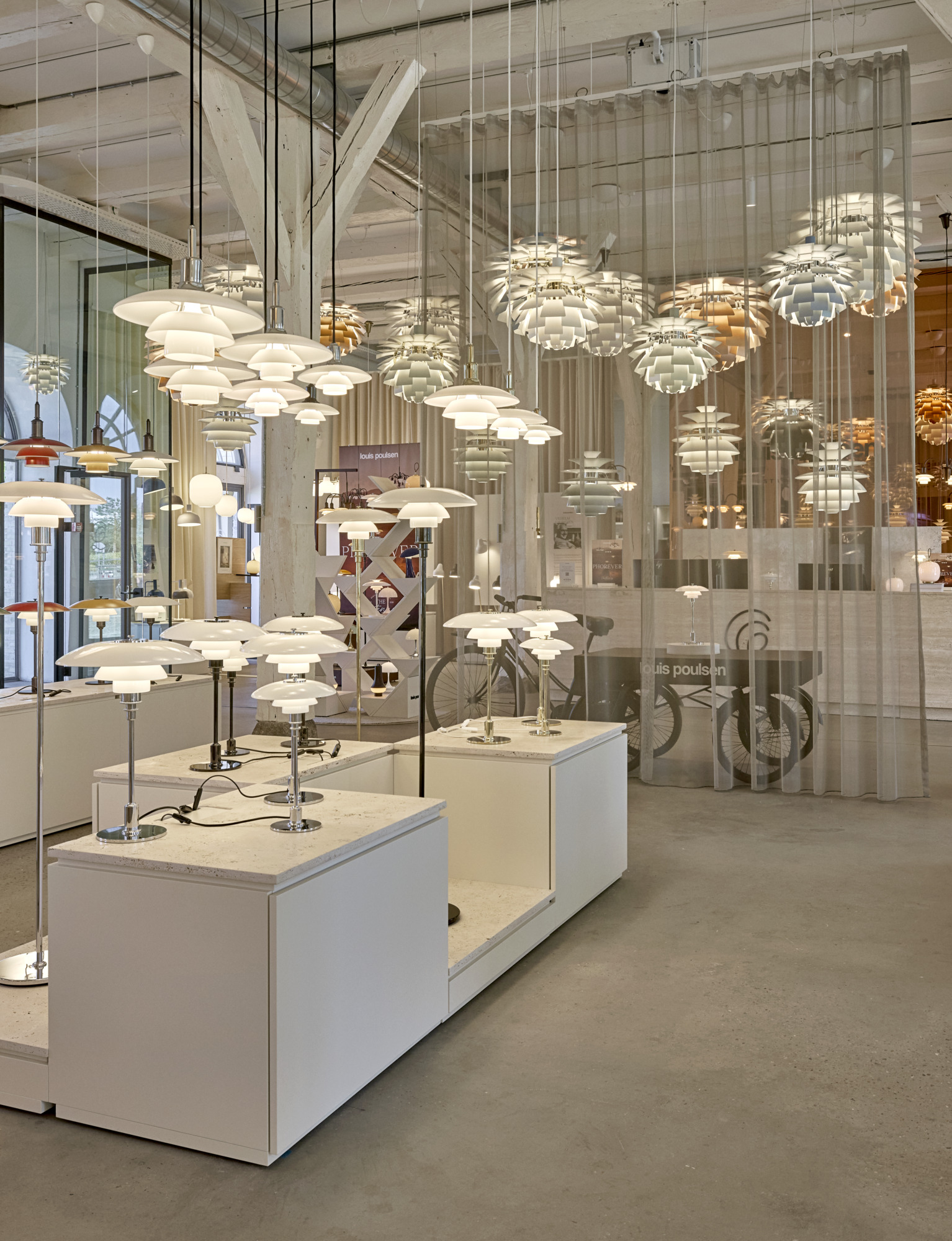 Louis Poulsen showroom in Copenhagen with PH and Artichoke lamps displayed indoors, © 2025 Louis Poulsen.