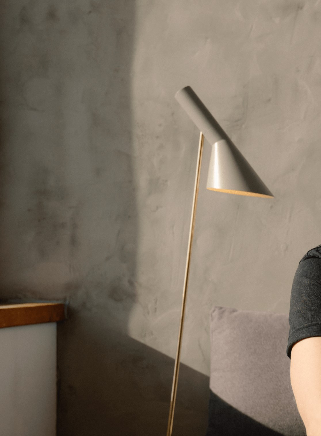 AJ Floor lamp casting light in a minimalist corner setting, © 2025 Louis Poulsen.