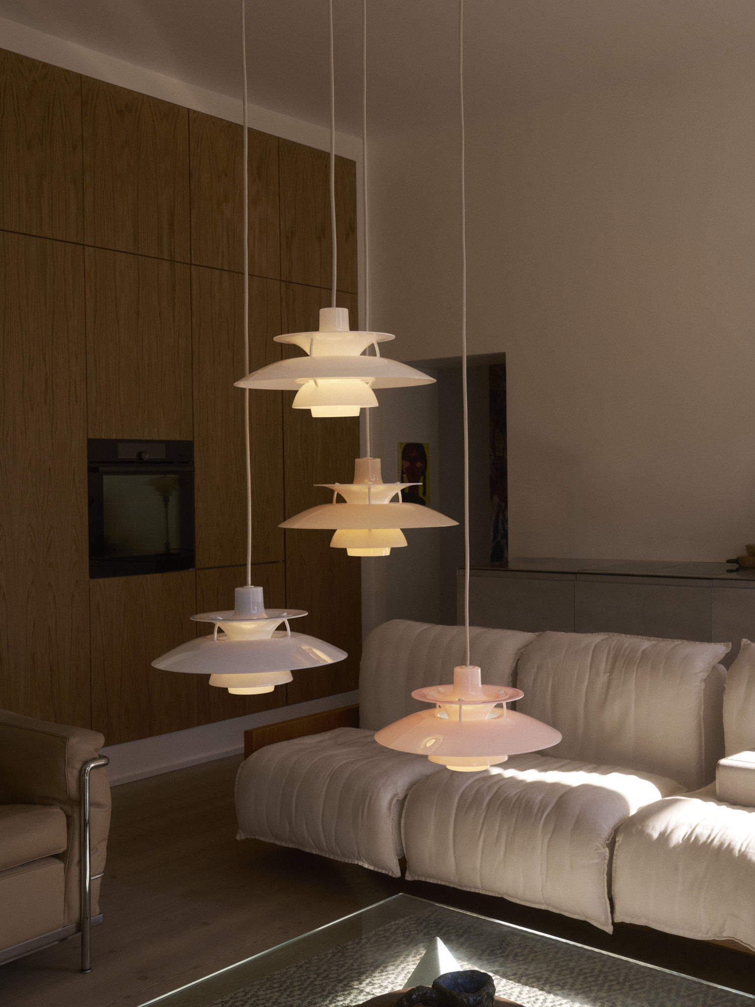 PH 5 Opal pendants in new colours above a sofa in a warm living room, © 2025 Louis Poulsen.