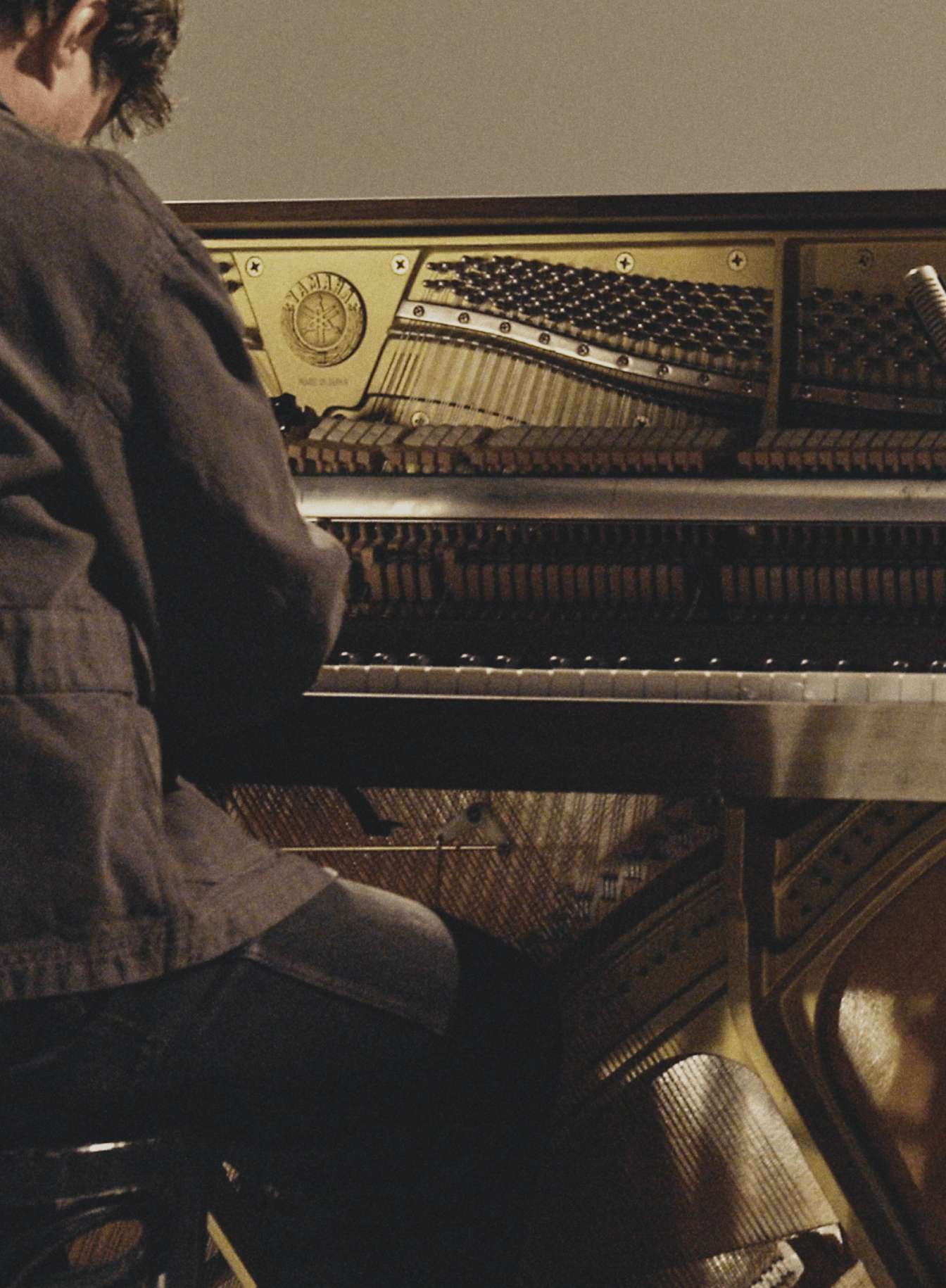August Rosenbaum playing an open upright piano, © 2025 Louis Poulsen.