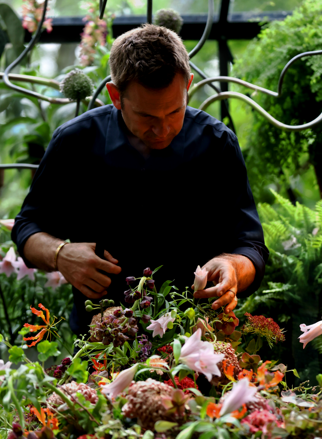 Nicolai Bergmann arranging flowers with PH 3/2 Limited Edition Table Lamp nearby, © 2025 Louis Poulsen.