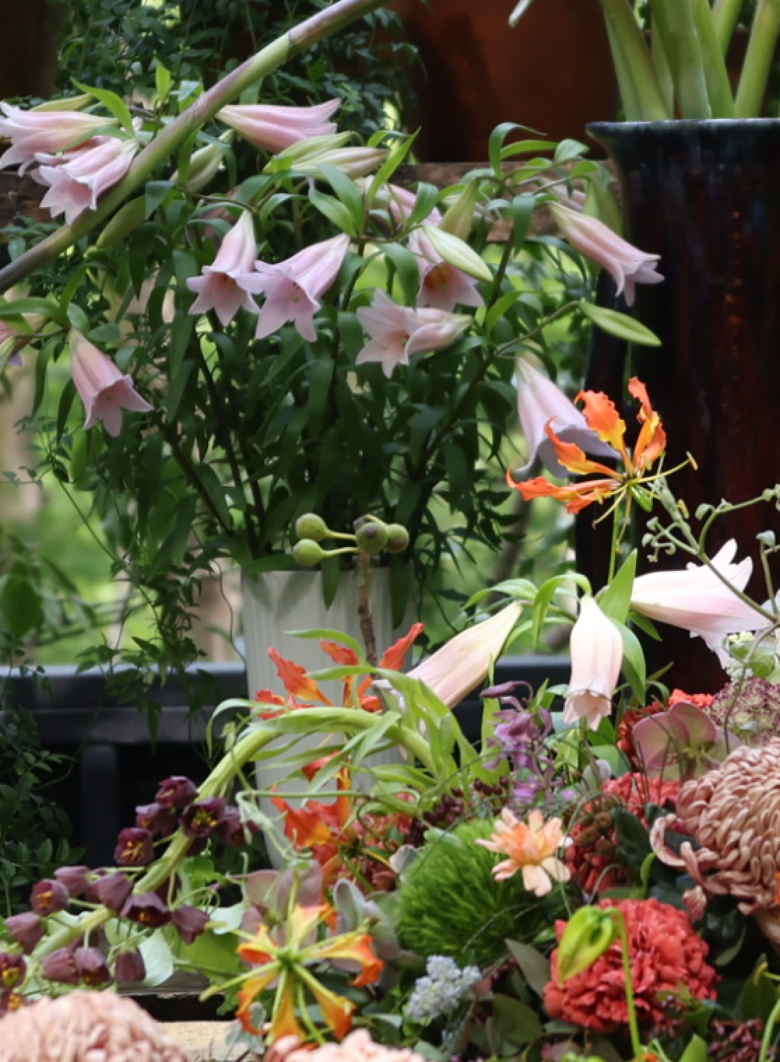 Pink lilies and colourful flowers near PH 3/2 Limited Edition Table Lamp, © 2025 Louis Poulsen.