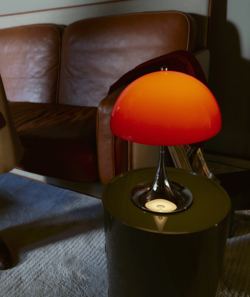Panthella 250 Portable in Red on a side table in a warm interior, © 2025 Louis Poulsen.